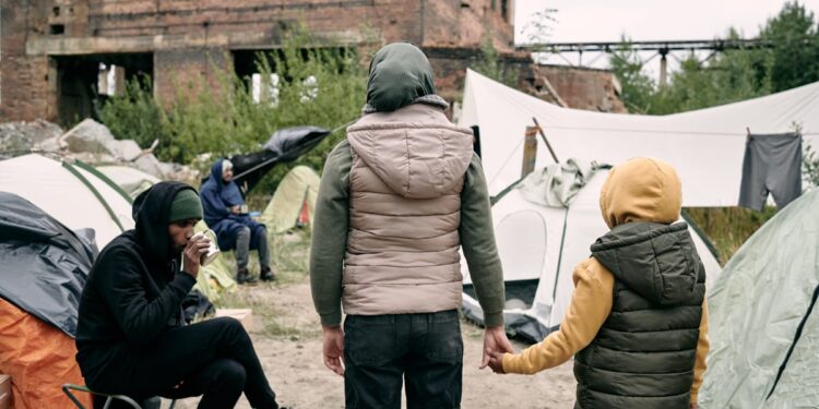 back view twow refugees standing front camp