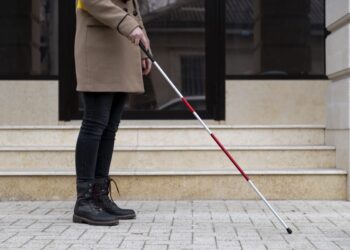 blind woman walking using her walking stick
