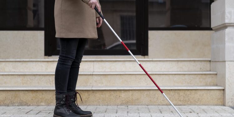 blind woman walking using her walking stick